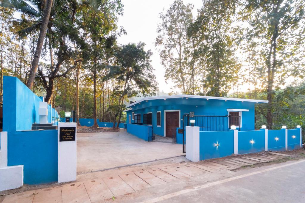 Blue exterior of Stefleena’s Nest surrounded by greenery